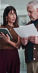 Mature man, woman and tablet at office, team and graphs proposal with documents at media company. People, tech and paperwork with planning, charts or talk with web traffic stats at creative agency
