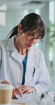 Woman, doctor and drinking coffee in office at hospital for report, administration and medical paperwork. Person, healthcare professional and drink with beverage, documents or writing notes at clinic