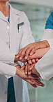 Team, doctors and stack hands for celebration, happy and circle with success in hospital corridor. People, group and motivation with applause, support and achievement in healthcare career at clinic