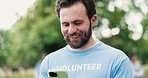 Laughing, phone and volunteer man in park for charity, community outreach or donation update. App, funny and typing with happy activist outdoor for social media post of ngo or non profit mission
