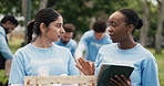 Volunteer, communication or people in park with tablet, group or package checklist in eco friendly project. Team, coordination or NGO outdoor with tech, inventory track or advice in charity donation.