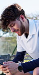 Tennis court, happy man and typing message with phone, fitness break and training practice pause. Workout rest, replying and person texting with mobile app outdoor, browsing social media and internet