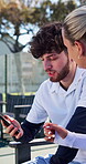 Fitness, friends and talking with phone on tennis court for match schedule, training app or break. Athlete, people or conversation with smartphone on bench for online game advice, rest or sports news