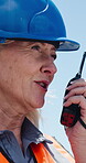 Construction, woman or talk on site with radio for building instructions, engineer report or update. Contractor, mature person outdoor or walkie talkie for discussion, risk assessment advice or chat.