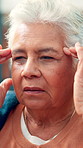 Home, headache and old woman with pain, tired and tension with temple massage. Apartment, pensioner and senior person on couch, migraine and health risk with burnout, sick and fatigue with illness