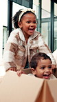 Happy family, children and playing with box in new home for fun ride, moving in or childhood. Youth, siblings and playful sister pushing brother in cardboard with guardians for fresh start together