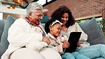 Grandma, mother and child with tablet in house for bonding together, ebook and storytelling website. Old woman, mom reading and daughter with generations on sofa for tech, digital kids book or story.