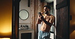 Brushing teeth, doorway and phone with man in bathroom of home for browsing or dental hygiene. App, communication and oral care with shirtless person in apartment for cleaning, health or wellness