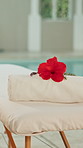 Leisure, spa and massage table at pool with flower, healing treatment or empty location in wellness center. Holistic, peace or swim area in resort with bed, serenity or zen in luxury retreat.