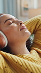 Woman, relax or stretching on sofa with headphones for calming music, peaceful moment or daydreaming. Female person, smile or rest in home with audio tech for online playlist, reflection or wellness.