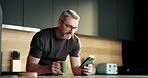 Mature man, phone and coffee in kitchen, texting and glasses for notification in morning at house. Person, smartphone and contact on mobile app, smile or scroll on social media with tea at apartment