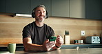 Phone, music and mature man in home with headphones for audio, track and playlist to relax. Dance, weekend and person listening to radio, song and streaming subscription for wellness in kitchen