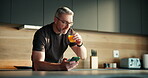Phone, freelancer and juice with man in kitchen for online article, planning or contact. Digital report, email newsletter and remote worker with mature person in home for  project update or drink