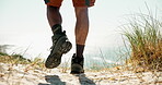 Feet, man outdoor and hiking with boots for travel adventure, vacation activity and beach scenery. Back, person legs and trekking on mountain with shoes for nature exploration, journey or ocean view.