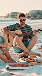 Beach, friends or man playing guitar with sunglasses, summer vacation or holiday with musical entertainment. Outdoor picnic, reunion or happy musician with acoustic instrument, chilling or people