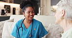 Senior woman, nurse and happy on sofa, discussion and assessment for wellness in retirement home. People, caregiver and smile with assisted living, talk or consultation on couch in lounge at house