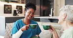 Happy, old woman and caregiver with coffee in lounge, laugh or conversation on break in nursing home. Assisted living, nurse and talking with elderly patient, retirement and people with warm beverage