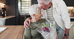Flowers, hug and kiss with senior couple in home together for anniversary, romance or valentines day. Bouquet, love and roses with old people embracing in apartment for bonding, marriage or security