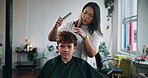 Salon, hairdresser and child with cape, haircut and hair maintenance with equipment or consultation. Hairstylist, appointment and woman with boy for haircare, grooming and process for hairstyle