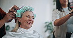 Women, talking or curlers in salon with hair care, maintenance or bonding together in appointment. Conversation, people or mature person in hairdresser with rollers for hairstyle, beauty or wellness.