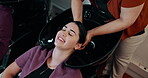 Above, beauty salon or woman at basin with treatment, cleaning or scalp product in head grooming. Cosmetic, happy client or stylist at faucet with conditioner, haircare or cleanse in wellness routine