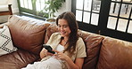 Above, woman and relax with phone on sofa for social media, browsing website and texting. Smile, female person and laughing with mobile, funny video and reading meme of weekend entertainment at house