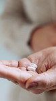 Hands, person and pills for medicine, wellness product or prescription drugs in home. Palm, medication and woman with tablets for supplements, healthy vitamins or medical benefits with cure closeup