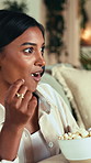 Shocked, woman eating and watching tv in apartment with popcorn for funny show, film or entertainment. Person, surprise or laugh in home with corn snack for comedy series, movie or streaming service.