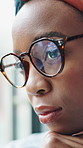 Black woman, thinking and reflection at window in home, glasses or insight for decision in lounge. African person, relax and perspective with memory, nostalgia or daydream in living room at apartment