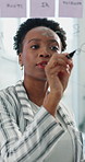 Creative, black woman and writing on glass in office for planning, ideas and schedule update. Female person, tablet and notes with agenda, reminder and brainstorming with mind map on project deadline