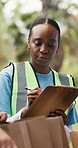 Woman, volunteer and writing on clipboard outdoor for food drive, donation inventory and charity event. Person, counting and checklist for resources, package inspection and planning for distribution