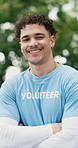 Face, volunteer and happy man with arms crossed at park for community service, non profit or NGO. Outdoor, charity worker and confident person with smile, social responsibility or portrait with bokeh