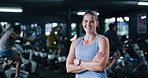 Face, fitness and happy woman in gym with arms crossed, confidence and spin class instructor. Portrait, smile and indoor cycling coach in health club for exercise, professional trainer and pride