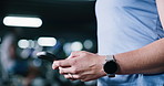 Hands, phone and person in gym for fitness, training information or check stats. Mobile, sports club and athlete typing for online communication, text app and tracking workout for health with bokeh