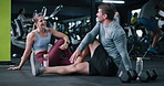 Happy, couple and stretching for fitness at gym with discussion, training and flexibility routine. People, talking and warm up to prepare muscles, mobility workout and improve posture for wellness