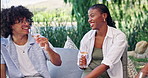 Happy friends, wine and picnic outdoor with chat for social gathering, connection and bonding together. People, laugh and talking with alcohol drink in nature for gossip, summer vacation and hangout.