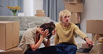 Couple, stress and moving in new home with laptop for relocation argument, unpacking issue or talk. Frustrated, married people and dispute in apartment with computer, real estate drama or discussion.