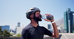 Drinking water, helmet and black man in city, training and hydration with wellness. African person, outdoor and cyclist with liquid, bottle and thirsty with aqua, fitness and nutrition with exercise