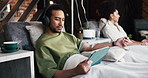 Man, tablet and drip therapy in lounge, relax or headphones with saline solution for immune system boost. Person, tech and iv for wellness benefits, vitamin or mineral infusion with app for streaming