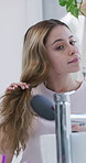 Woman, hairbrush and grooming at bathroom mirror in home, growth and self care with morning routine. Girl, keratin and hygiene with hairstyle, texture or comb with balayage for results at apartment