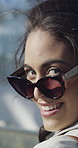 Face, woman and walking downtown with sunglasses for trendy style, travel vacation or weekend break. Female person, stylish shades or accessory in city with happiness for holiday, trip or confidence.