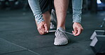 Tying, shoes and fitness in gym, hands and prepare for workout routine, feet or training for athlete. Walking, legs and person with footwear for exercise, wellness and bodybuilder with health goals
