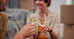 Couple, toast champagne and new home with hands, celebration and boxes on floor at property. Happy woman, man and excited with sparkling wine, achievement and relocation with real estate investment