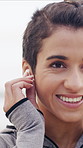 Fitness, earphones and woman at beach with smile, online radio or song subscription for start of workout. Happy, sport or athlete outdoor with tech, streaming playlist or getting ready with audio app