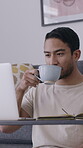 Drinking, coffee and man with laptop, home and freelancer with article, copywriting and proofreading. Online, email marketing and person with tea in living room, creative and remote work for blog