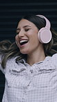 Happy woman, dancing and listening with headphones for music, energy or vibe on garage door. Female person, user or smile with songs, sound app or carefree for audio streaming or fun entertainment