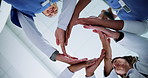 Below, nurses and doctor with hands circle for huddle, teamwork or motivation in hospital. People, employees or healthcare professionals with stack for medical solidarity, collaboration or support