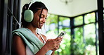 Home, headphones and woman with fitness, cellphone and listening to music, app and subscription. Audio streaming, smartphone and person with radio, exercise or relax with sound and playlist album
