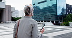 Business, back and woman in city, smartphone and location with digital app for direction. Outdoor, employee or mature person with cellphone, travel and navigation with internet or commute in New York