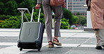 Legs, business people and walking with luggage in city for work trip, corporate travel and journey. Professional team, feet and employees with suitcase outdoor for conference arrival and destination